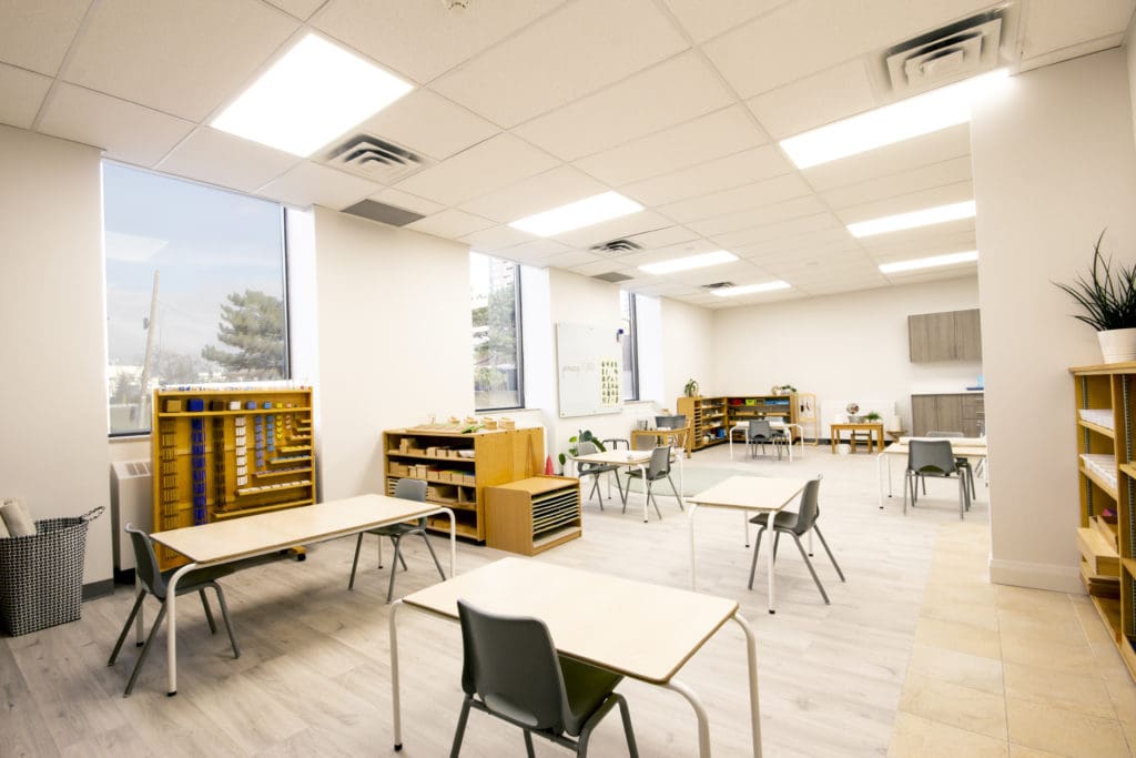 A classroom with tables and chairs in it