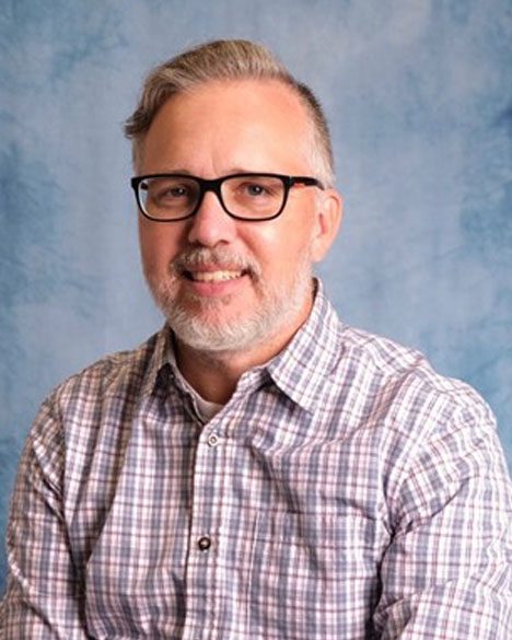 A man with glasses and a plaid shirt.